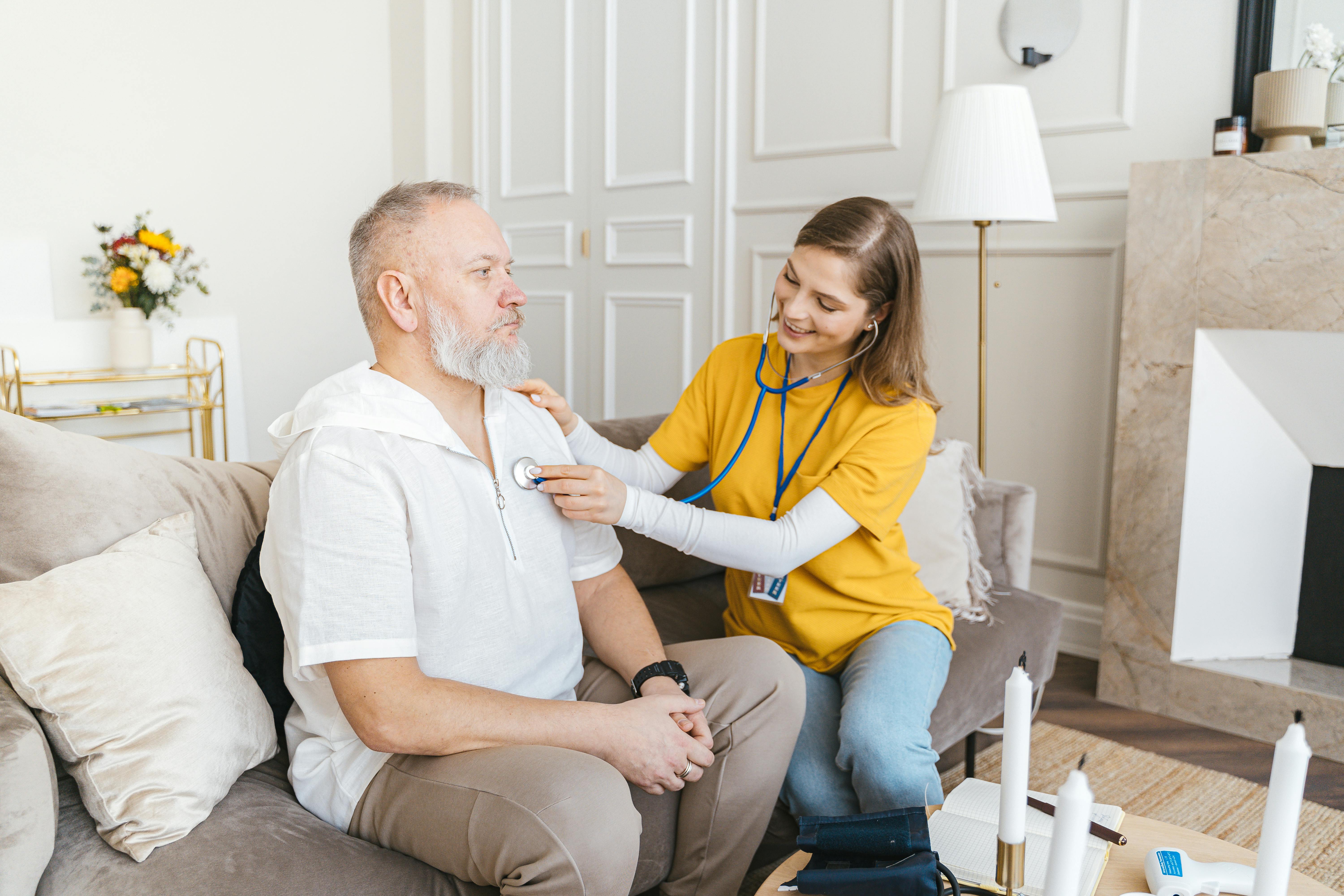 Elderly person smiling while being assisted by a professional caregiver